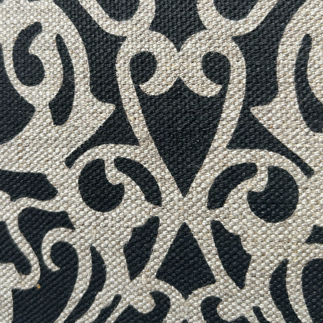 Handprinted fretwork cushion cover in black on natural linen with architectural design