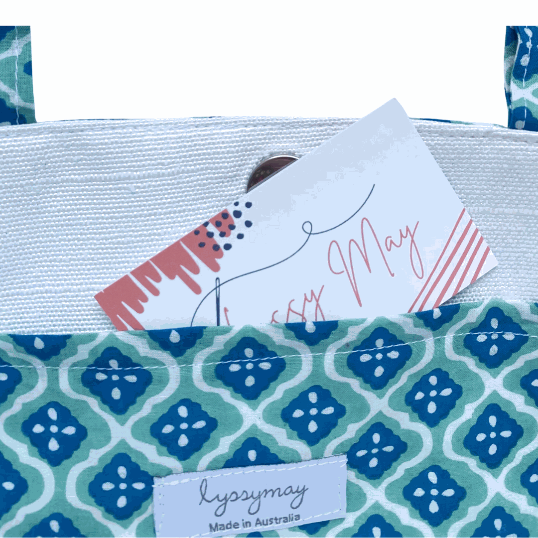 Noosa Escape Chopstick Handle Clutch Bag with vibrant blue and sea green block-printed cotton and white chopstick handles.