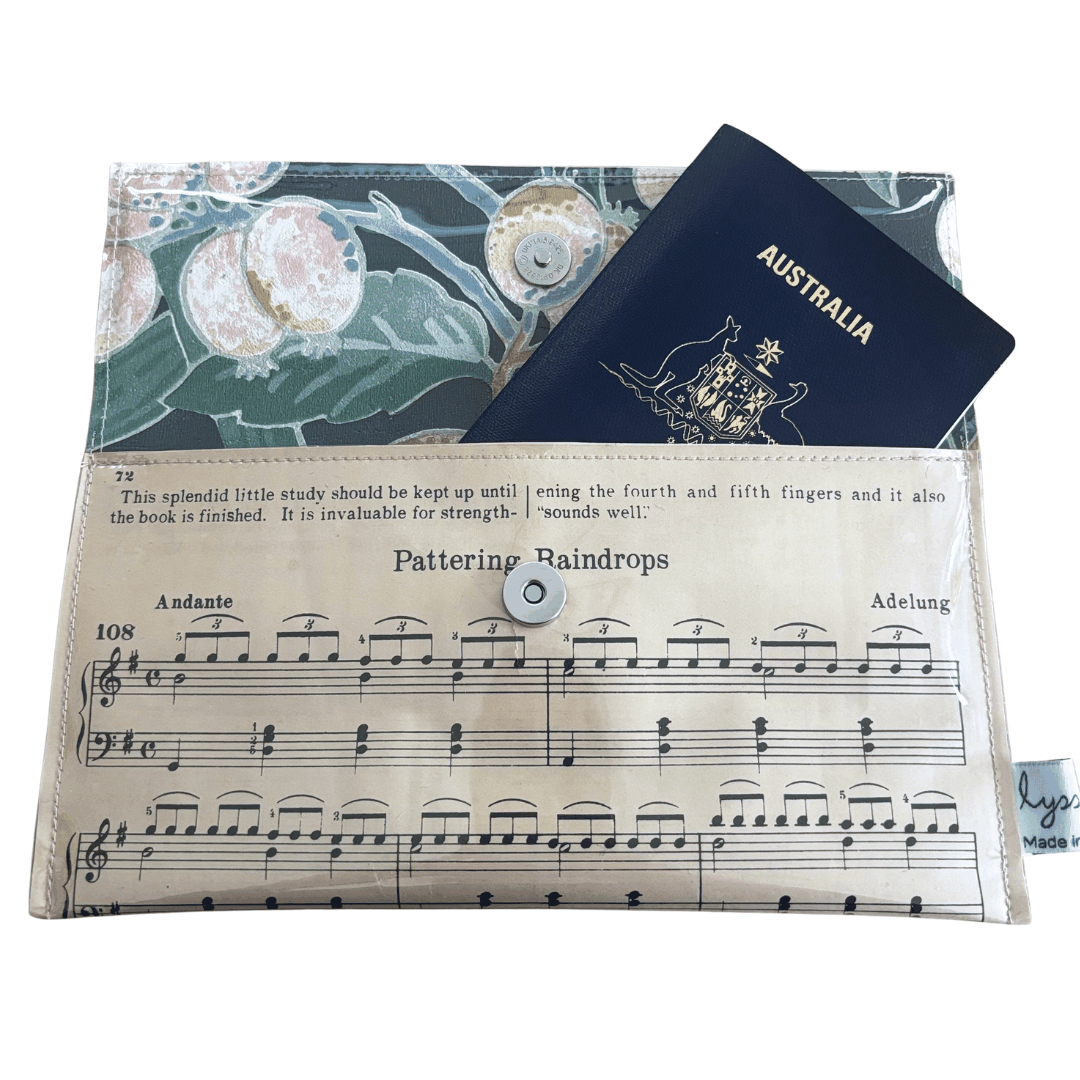 Vintage sheet music wallet made from 1940s piano lesson book page featuring "Pattering Raindrops" and "Crossing the Bridge" with floral wallpaper lining and magnetic clasp