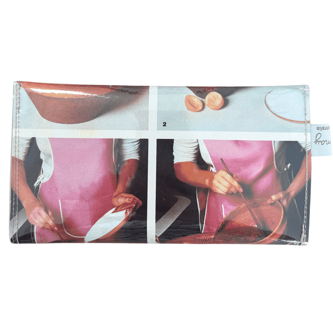 Handmade wallet with images of a person cooking, featuring a pink apron on the back of the design.