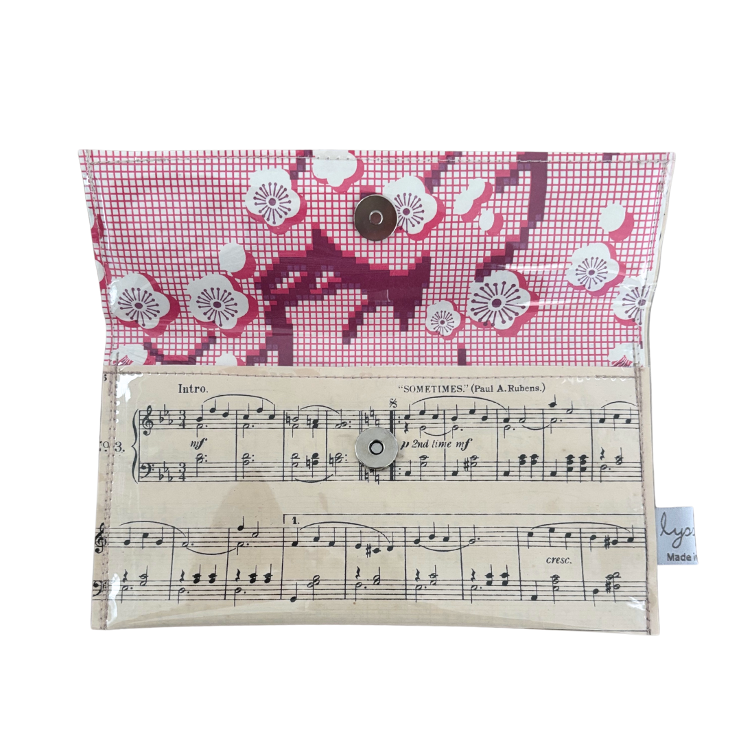 Small pouch with floral pattern on top and sheet music design on the bottom, on a white background.
