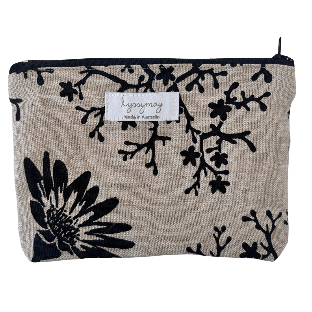 Fabric pouch with black floral pattern on beige background, featuring lyssymay brand label.