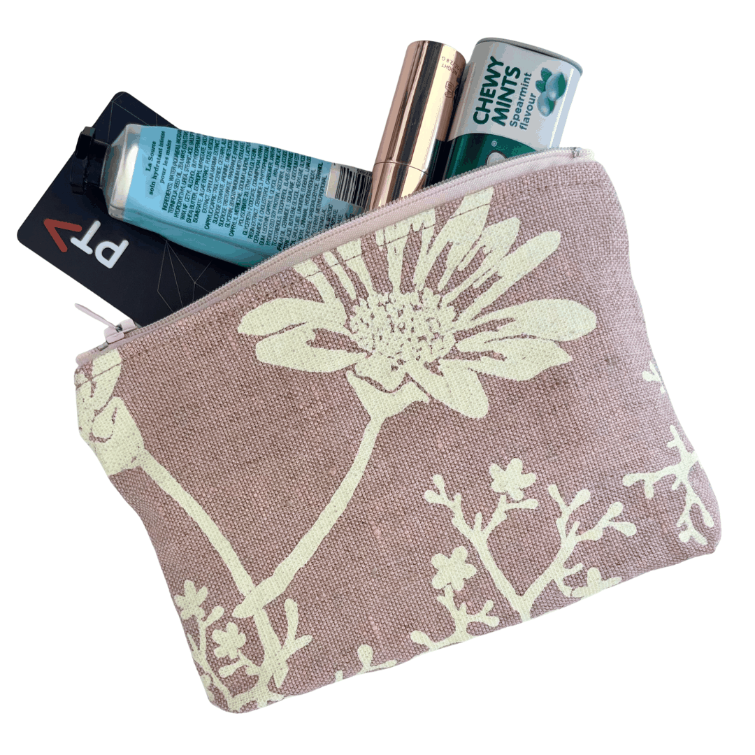 Floral-patterned pouch with lip balm, mints, small handcream and transport card on a white background