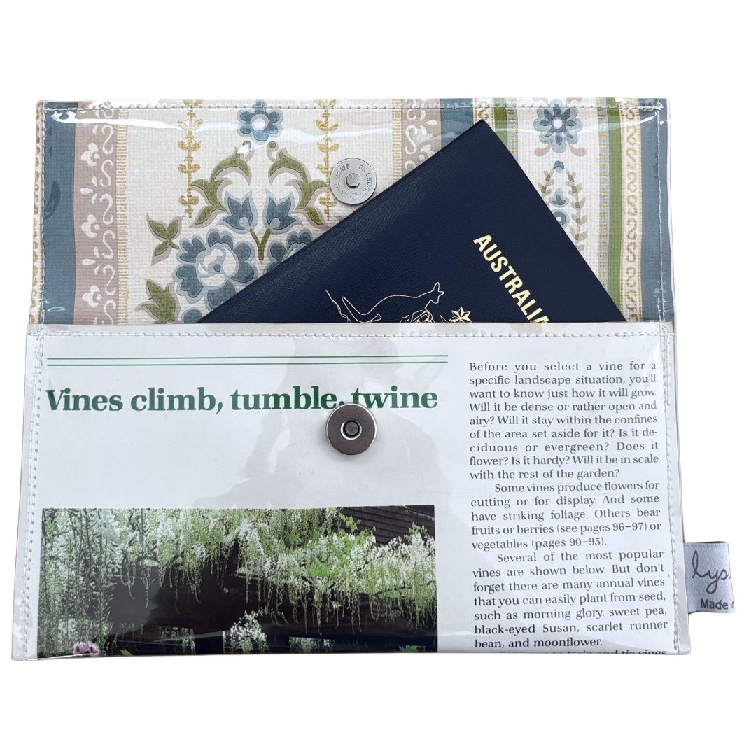 Floral-patterned handmade wallet which fits a passport, featuring text and images on the cover.