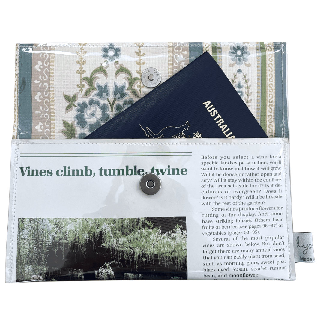 Floral-patterned handmade wallet which fits a passport, featuring text and images on the cover.
