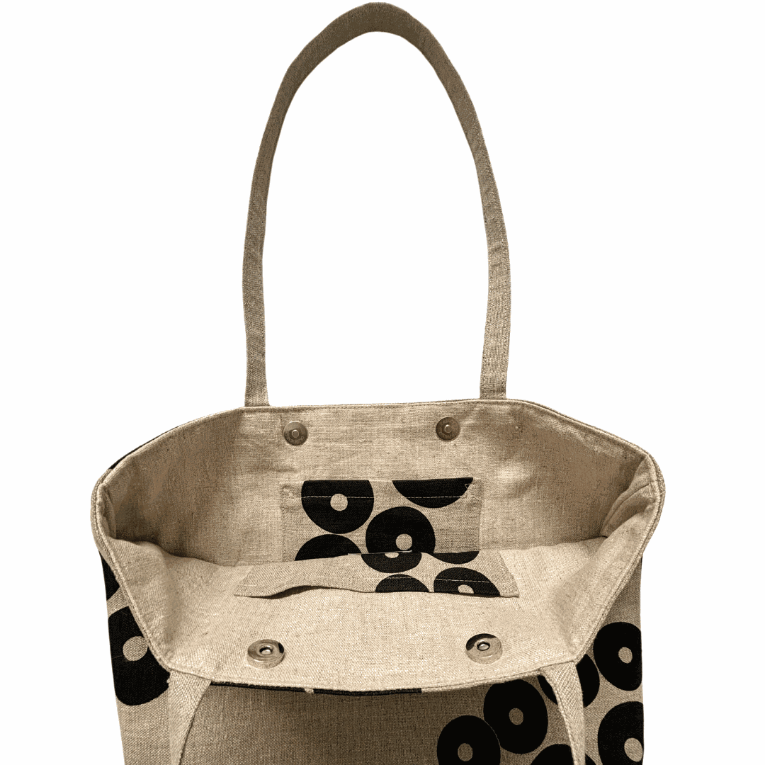 Beige tote bag with black circular patterns on a white background inside pockets