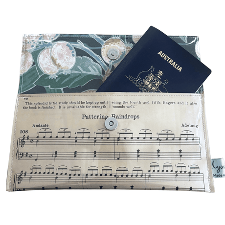 Vintage sheet music wallet made from 1940s piano lesson book page featuring "Pattering Raindrops" and "Crossing the Bridge" with floral wallpaper lining and magnetic clasp
