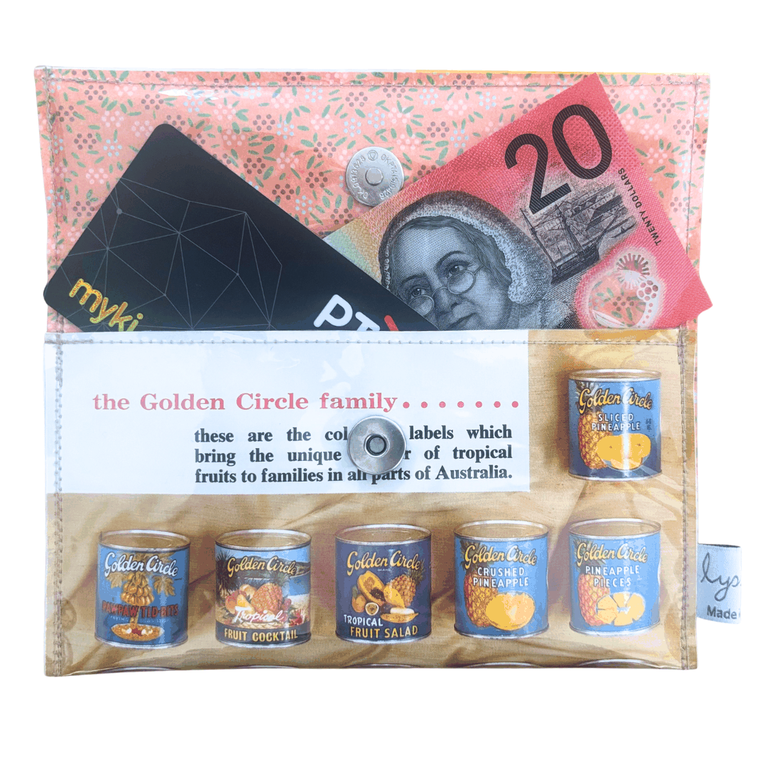 Wallet with Golden Circle fruit salad tins, Australian currency, and a myki card.