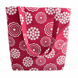 A handprinted cottage garden handmade shoulder bag in white and rouge with a floral pattern on a red background.