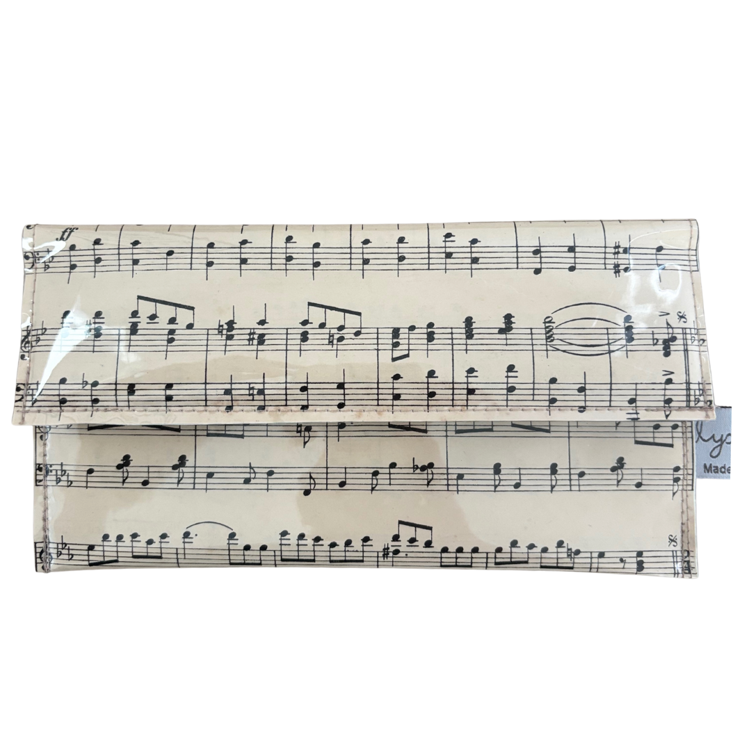Foldable clutch with music sheet design on a white background