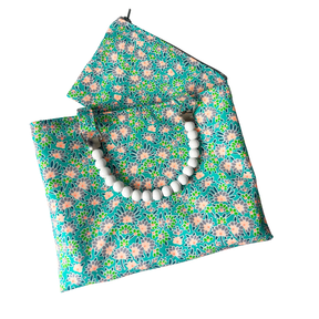 Floral-patterned towel with a wooden bead handle on a white background