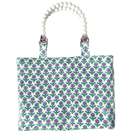 Floral patterned bag with a beaded handle on a white background