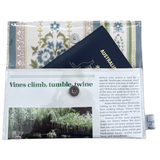 Floral-patterned handmade wallet which fits a passport, featuring text and images on the cover.