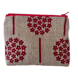 Fabric pouch with red floral patterns on a natural linen background