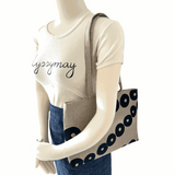 Mannequin wearing a linen tote bag with black circular pattern 