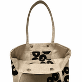 Beige tote bag with black circular patterns on a white background inside pockets